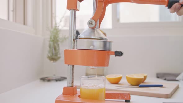 Super slow motion of fresh orange juice squeezed using a manual squeezer