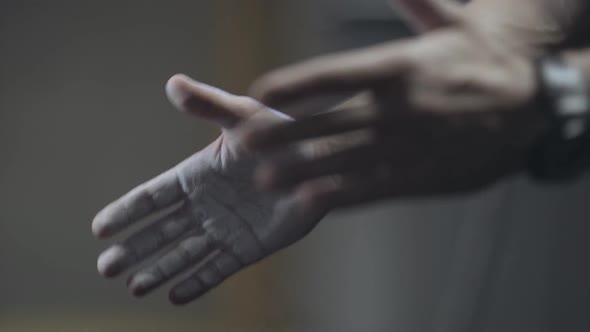 Close-up of Male Hands Clapping in Darkness. Unrecognizable Male Bodybuilder Training in Gym. Sport