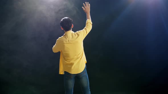 Back View Of A Young Boy Holding A Microphone And Rapping On The White Smoke Black Background