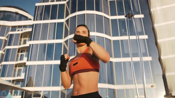 Young Woman is Boxing By Hands Wrapped in Bandage Tape