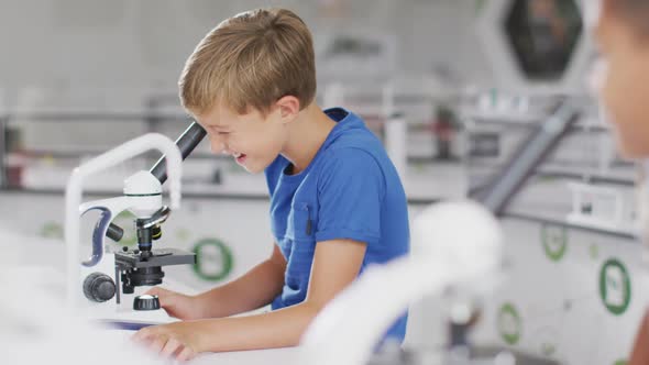 Video of happy caucasian boy with microscope during lesson alt