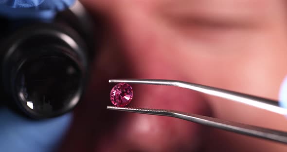 Jeweler Checks Gemstones for Authenticity Through Magnifying Glass