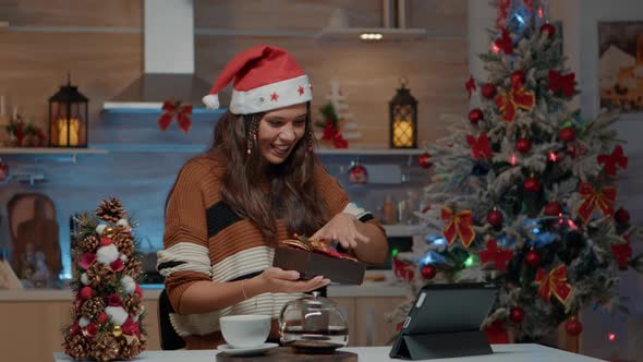 Smiling Woman Opening Gift From Friends on Video Call
