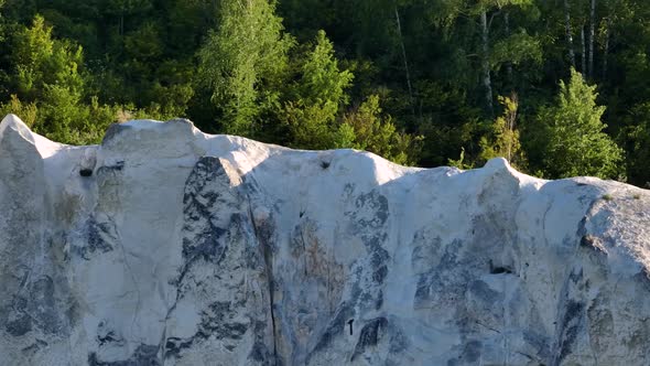 Aerial Video Footage of White Rocks Against the Backdrop of a Forest