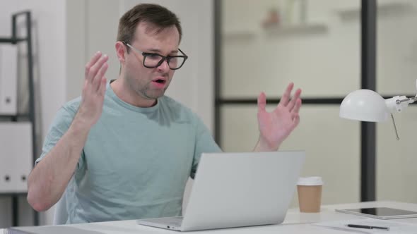 Young Man with Laptop Having Loss Failure