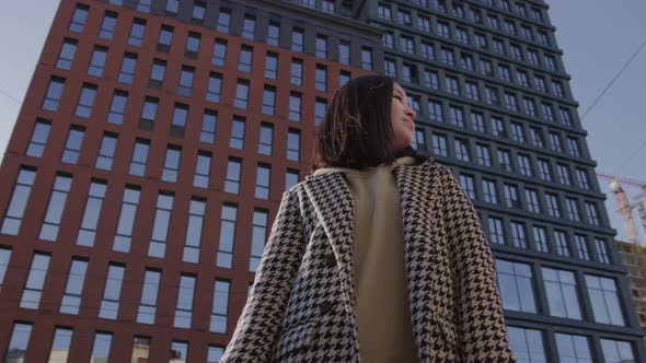 Low Angle Shot of an Asian Woman in Downtown Camera Pivoting Around