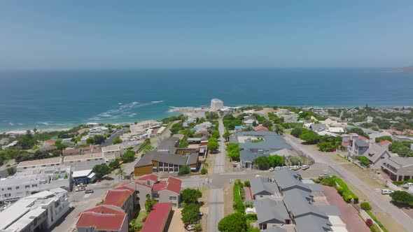 Forwards Fly Above Streets and Buildings of Coastal Town