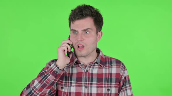 Portrait of Aggressive Young Man Angry on Smartphone Green Chroma Screen