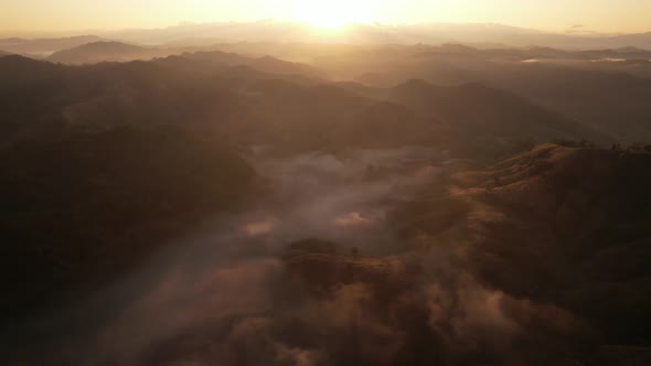 Aerial view of sunrise with fog above mountains