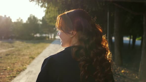 Pretty Lady Turns Back Shaking Hair Walking Along Park Road