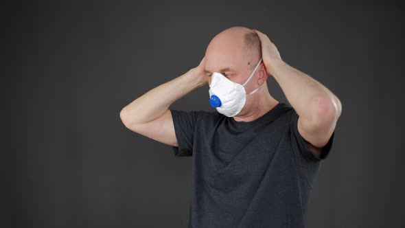 Focused Mature Man Wearing and Taking Off Respirator