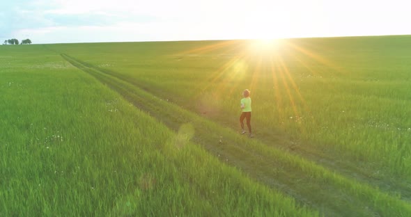 Sporty Child Runs Through a Green Wheat Field