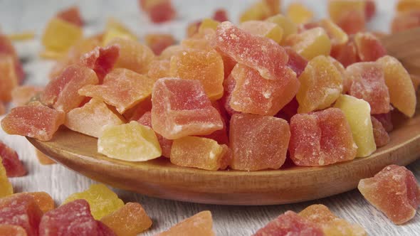 A full wooden spoon of dried papaya fruit cubes