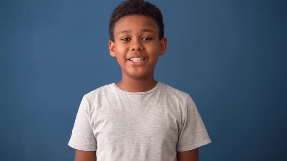 Multiracial male child showing joy and happiness. Blue background