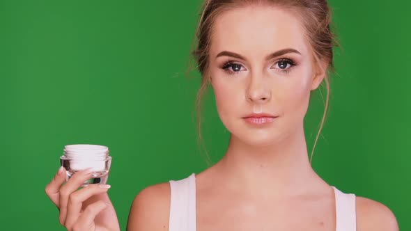 Woman Having Cream in Her Hand and Blinking with Her Eyes