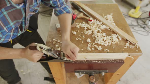 Close up carpenter planning to smooth the face of wood