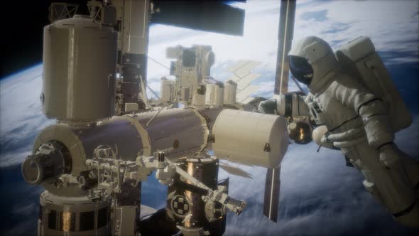 International Space Station and Astronaut in Outer Space Over the Planet Earth alt