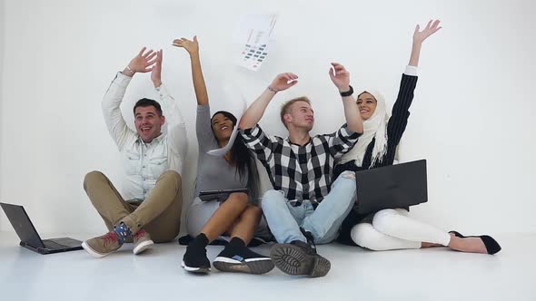 Mixed Race Office Team throw Up a Lot of Papers and Giving High Five