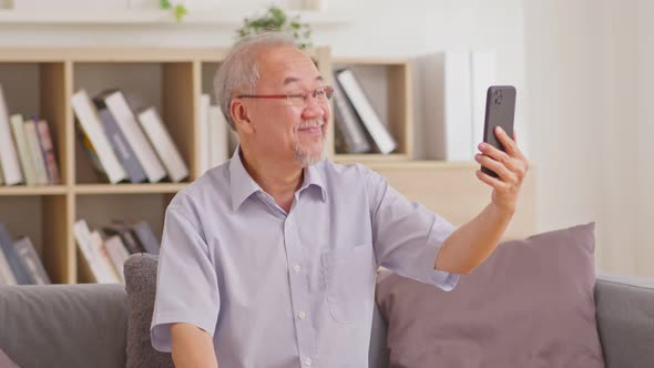 Asian elderly man making video call on smart phone, online call,  digital technology service consult