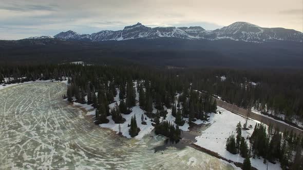 Flying view over a frozen forest in the mountains
