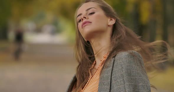 Gorgeous Caucasian Woman Shaking Her Long Brown Hair and Smiling To the Camera. Elegant Lady in