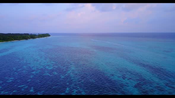 Aerial drone shot panorama of idyllic shore beach vacation by aqua blue sea and white sandy backgrou