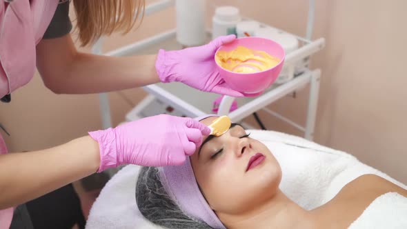 Young woman gets beauty facial injections in salon.
