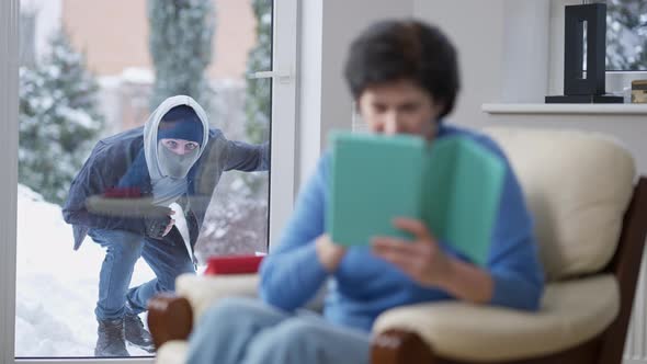 Unfortunate Thief Looking Inside House Through Glass Door As Blurred Woman Turning and Noticing