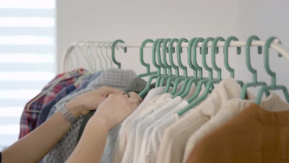 Women Are Studying Clothes Hung on a Hanger. Choosing a Wardrobe Is Very Important for Modern Women