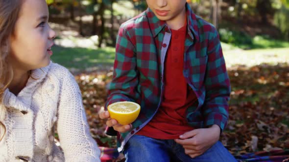 Little boy showing a lemon to his friend