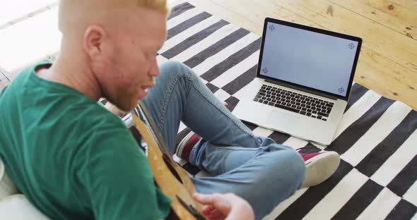 Albino african american man with dreadlocks playing guitars and singing