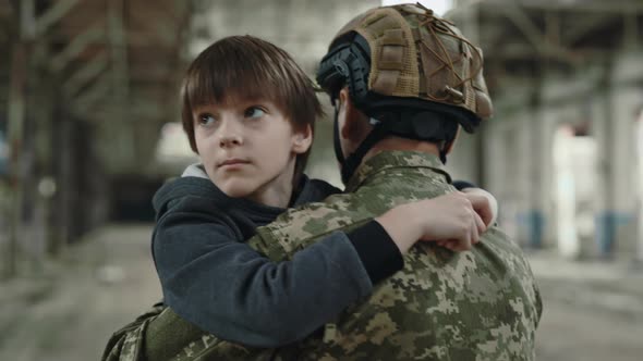 Soldier Carrying Boy on Shoulders Through Destroyed Factory