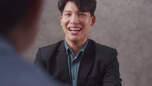 Asian businessman sitting in a modern office while interviewing for a new job.