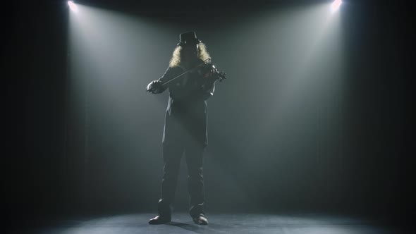 A Male Musician Violinist Plays a Musical Instrument. Silhouettes of a Man in a Black Suit and an