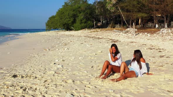 Beautiful ladies happy and smiling on paradise sea view beach time by aqua blue ocean with white san