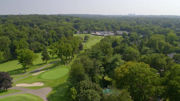 Backwards Aerial Pan of a Golf Course near a Forest