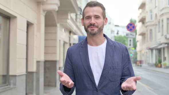 Mature Adult Man Talking on Video While Walking Down the Street