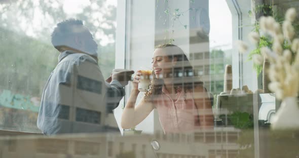 Happy diverse couple spending time together at cafe, drinking coffee and talking