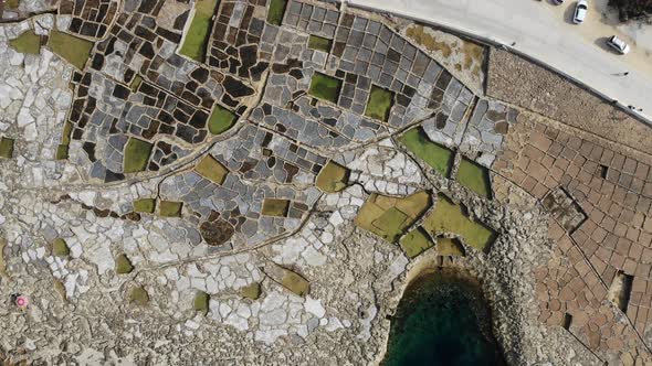 Ascending aerial drone shot of the ancient Salt Pans on the island of Gozo in Malta.