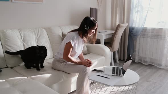 Young Woman Talking on Laptop at Online Conference While Working From Home