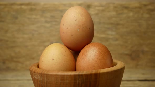 Rotation of eggs in a wooden plate on a wooden background. Easter concept.close up.Easter eggs