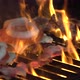 Two juicy delicious-looking burgers roast on the grill. The fire is sizzling - VideoHive Item for Sale