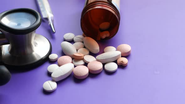 Close Up of Colorful Pills and Stethoscope on Purple Background 