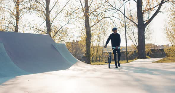 A Young Rider Dressed in Comfortable Clothes with Protective Helmet on Head is Heading Across