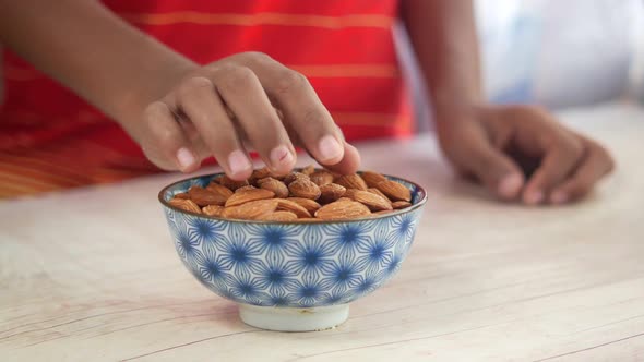 Child Boy Hand Pick Almond Nut on Table