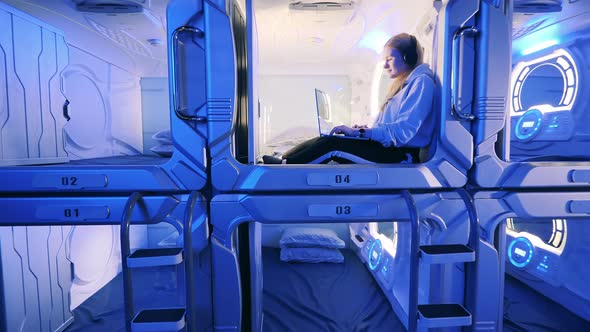 Capsule Hotel Units with a Girl Listening to Music in One of Them