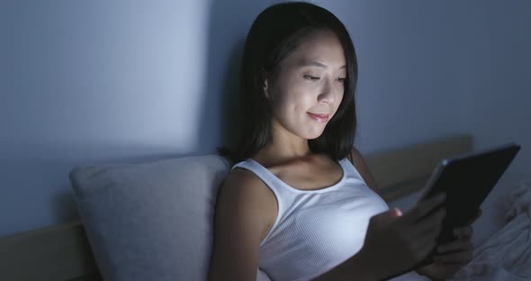 Woman using tablet computer at home in the evening 