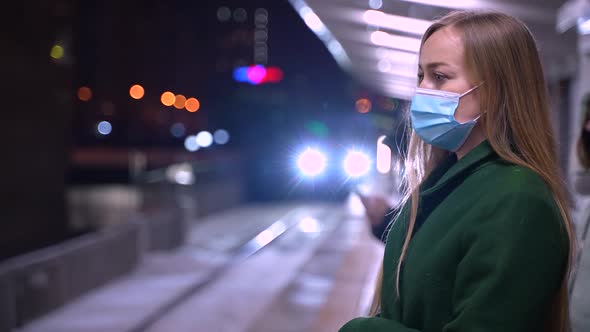 Masked Woman Waiting for Metro Train on Platform