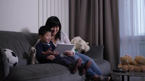 Happy Mom and Son Watching Cartoons on Tablet
