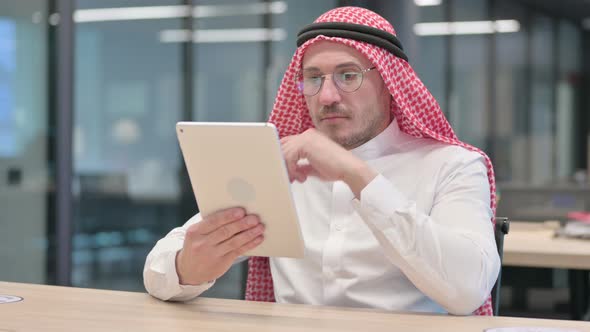 Middle Aged Arab Man using Tablet in Office